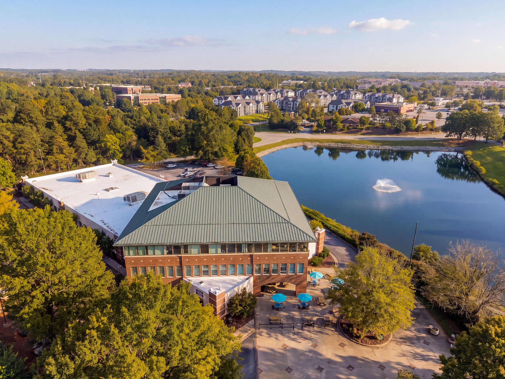 Aerial view of the Signature Hair Restoration clinic building beside the lake in High Point, NC