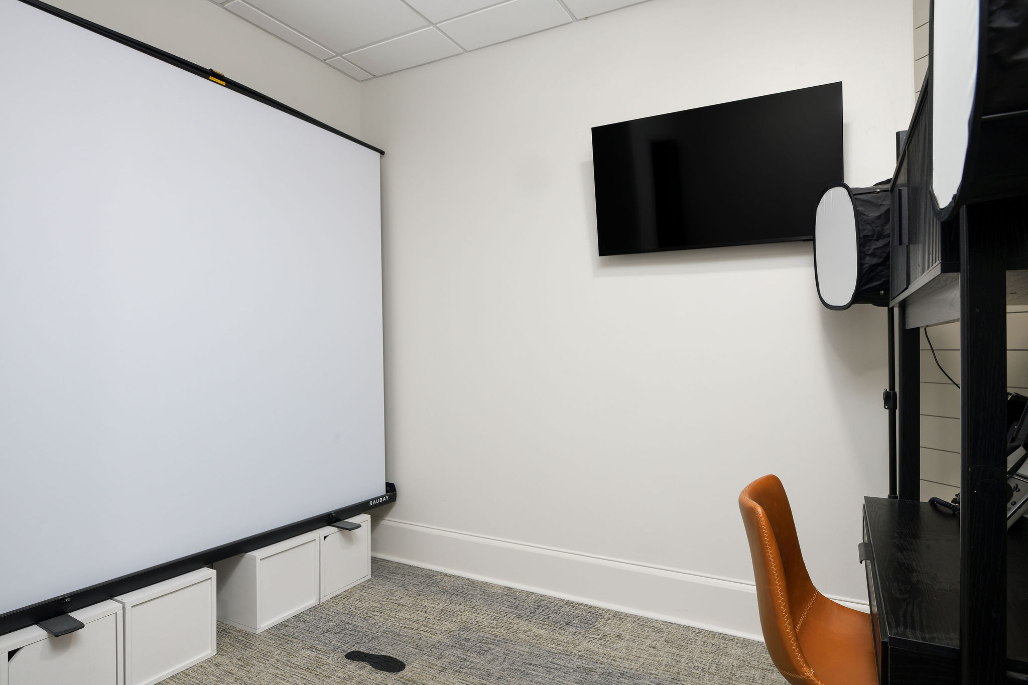 Patient photography and evaluation setup with backdrop, wall screen, and lighting